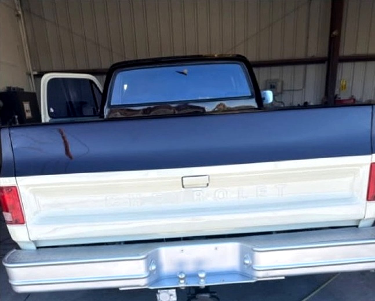 The same tailgate after: black over cream, glossy, inside the shop