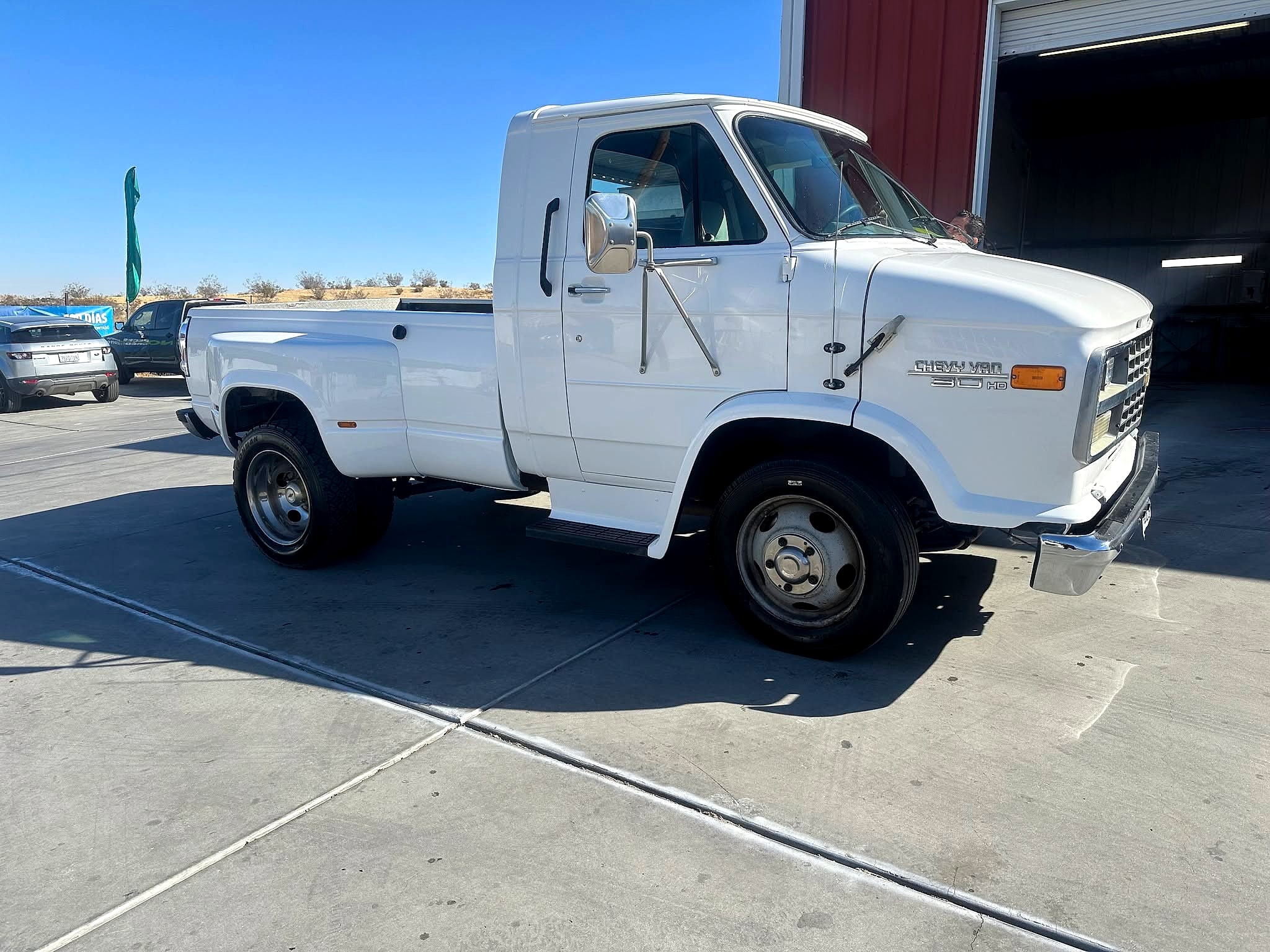 Finished gloss white Chevy Van 30 HD dually pickup outside the shop