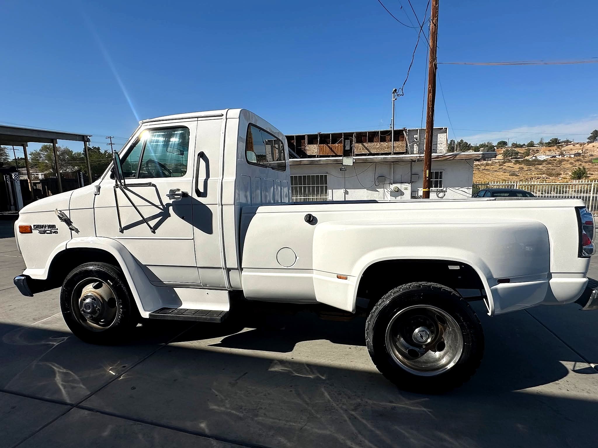 Finished white Chevy Van 30 HD dually in full side profile outside