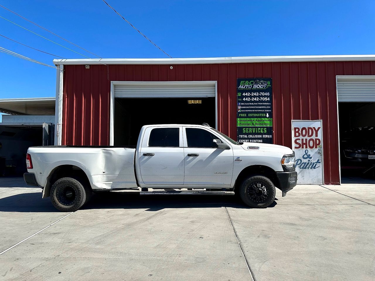 White Ram 3500 parked in front of the barn-red E&C shop with its banner and hand-painted door