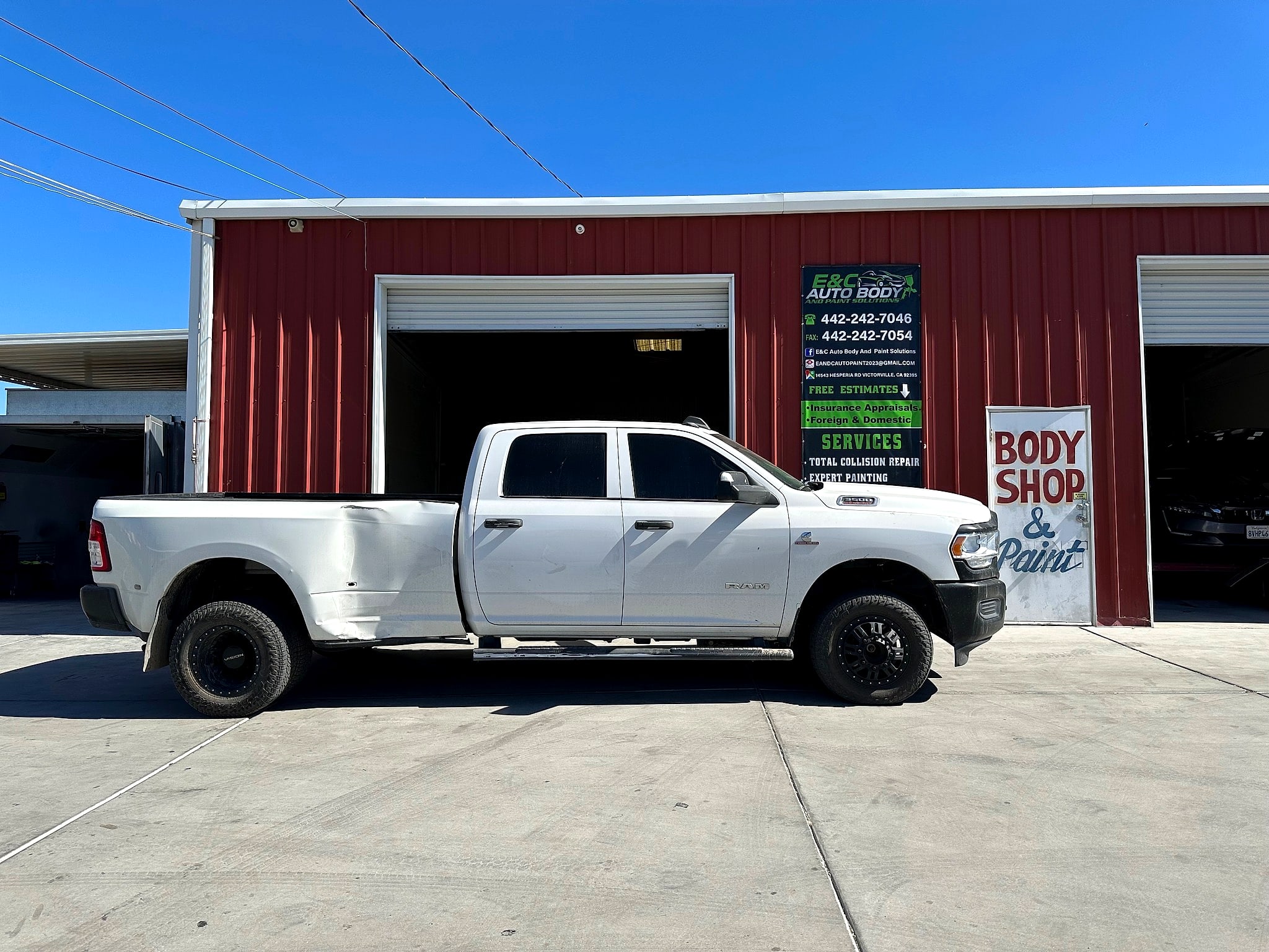 White Ram 3500 parked in front of the barn-red E&C shop with its banner and hand-painted door