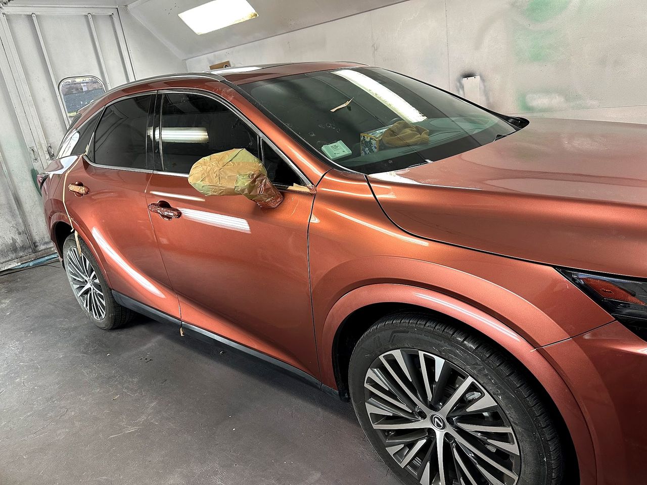 Copper Lexus RX with fresh glossy paint inside the E&C paint booth, mirror masked